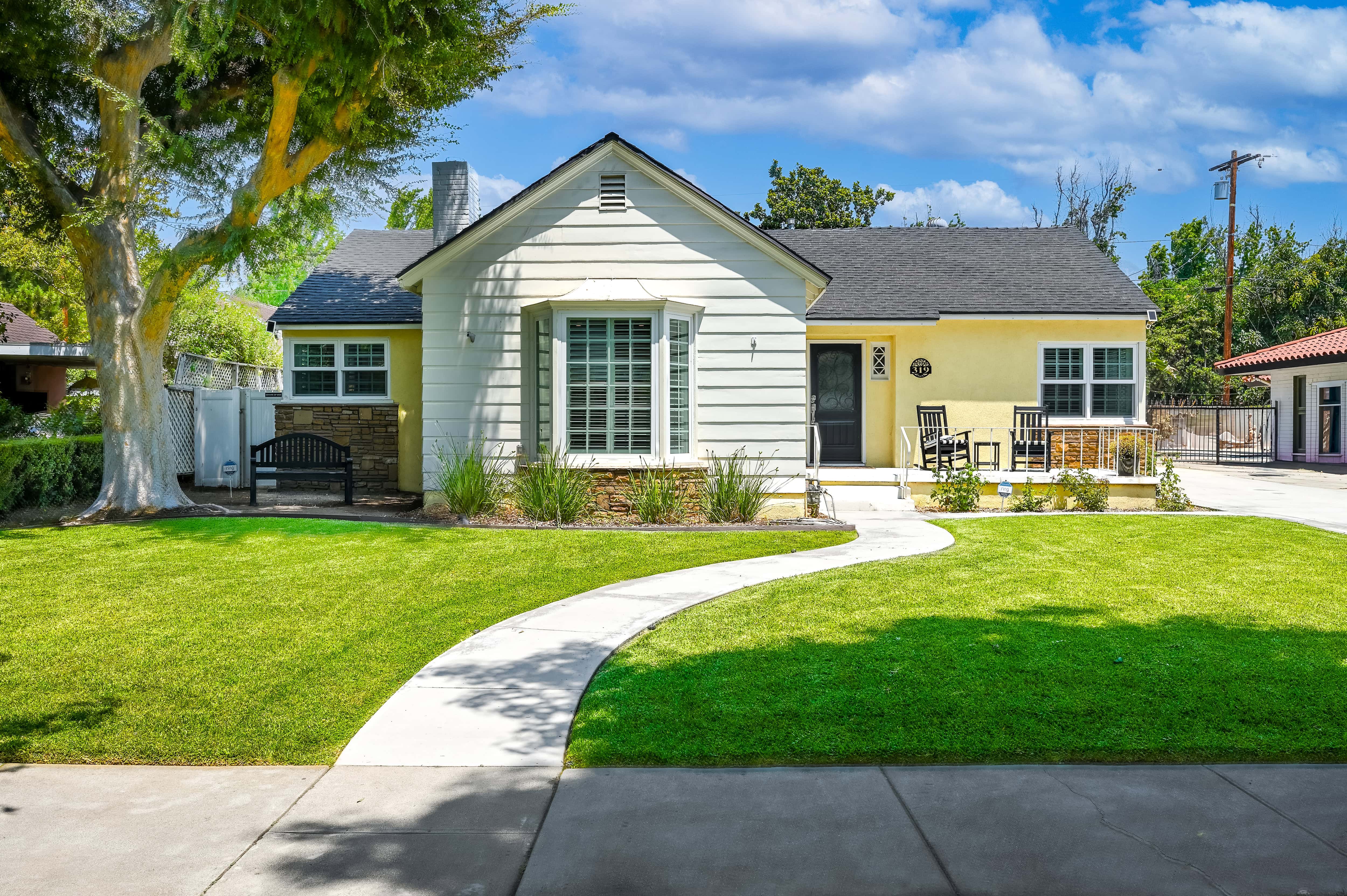 hemet real estate photography of a yellow house on a beautiful quiet street.